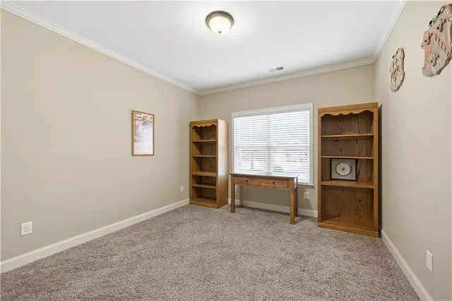a view of an empty room with a window and cabinet