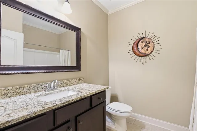 a bathroom with a granite countertop sink and a toilet