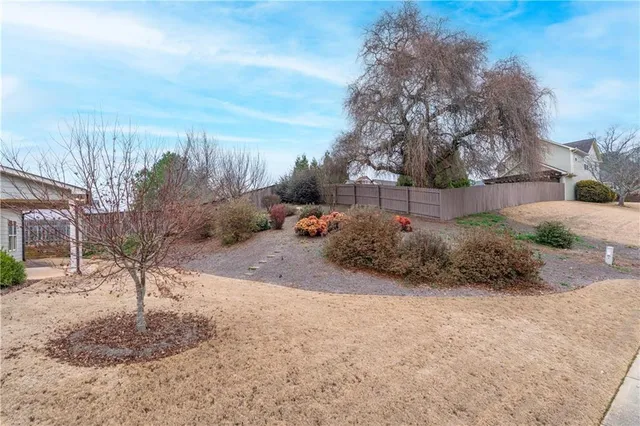 a view of a white house with a yard and potted plants