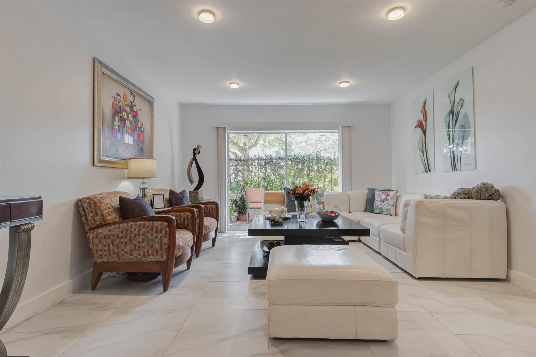 2234 South Piney Point Road, Unit 110 Houston, TX 77063 - Photo 8 of 25 A bright, modern living room with white walls and sleek tile flooring. Lighting is inviting and cozy.