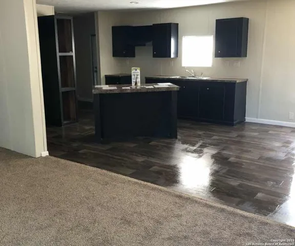 a kitchen with granite countertop a stove a sink and a microwave