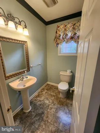 a bathroom with a toilet a sink and a window
