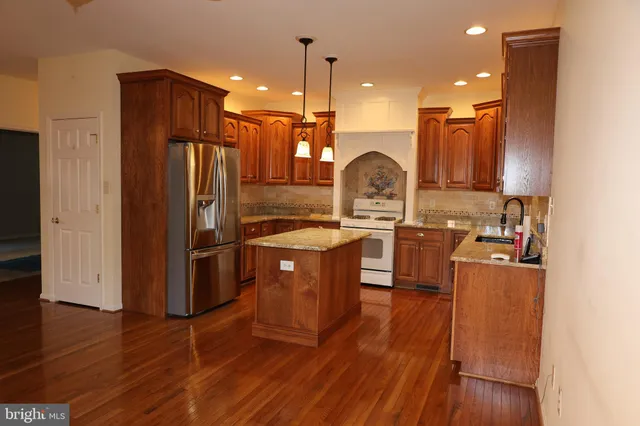 a kitchen with wooden floors and stainless steel appliances