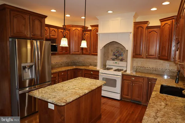 a kitchen with stainless steel appliances granite countertop a refrigerator and a sink