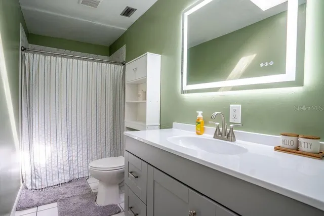 a bathroom with a sink a toilet and mirror