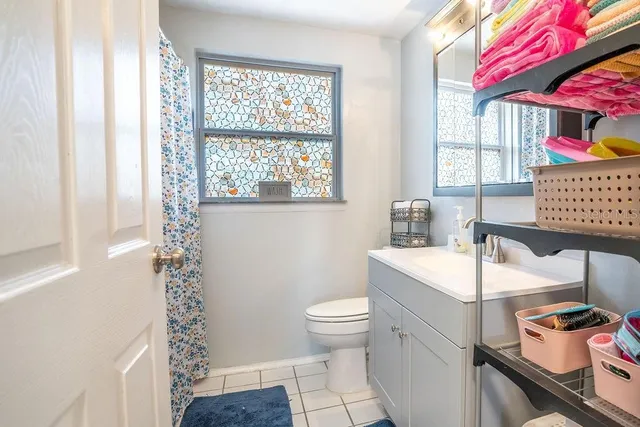 a bathroom with a sink a toilet and a window