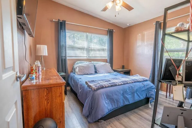 a bedroom with a bed and a flat tv screen on dresser