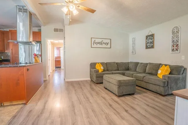 a living room with couches and painting on the wall with wooden floor