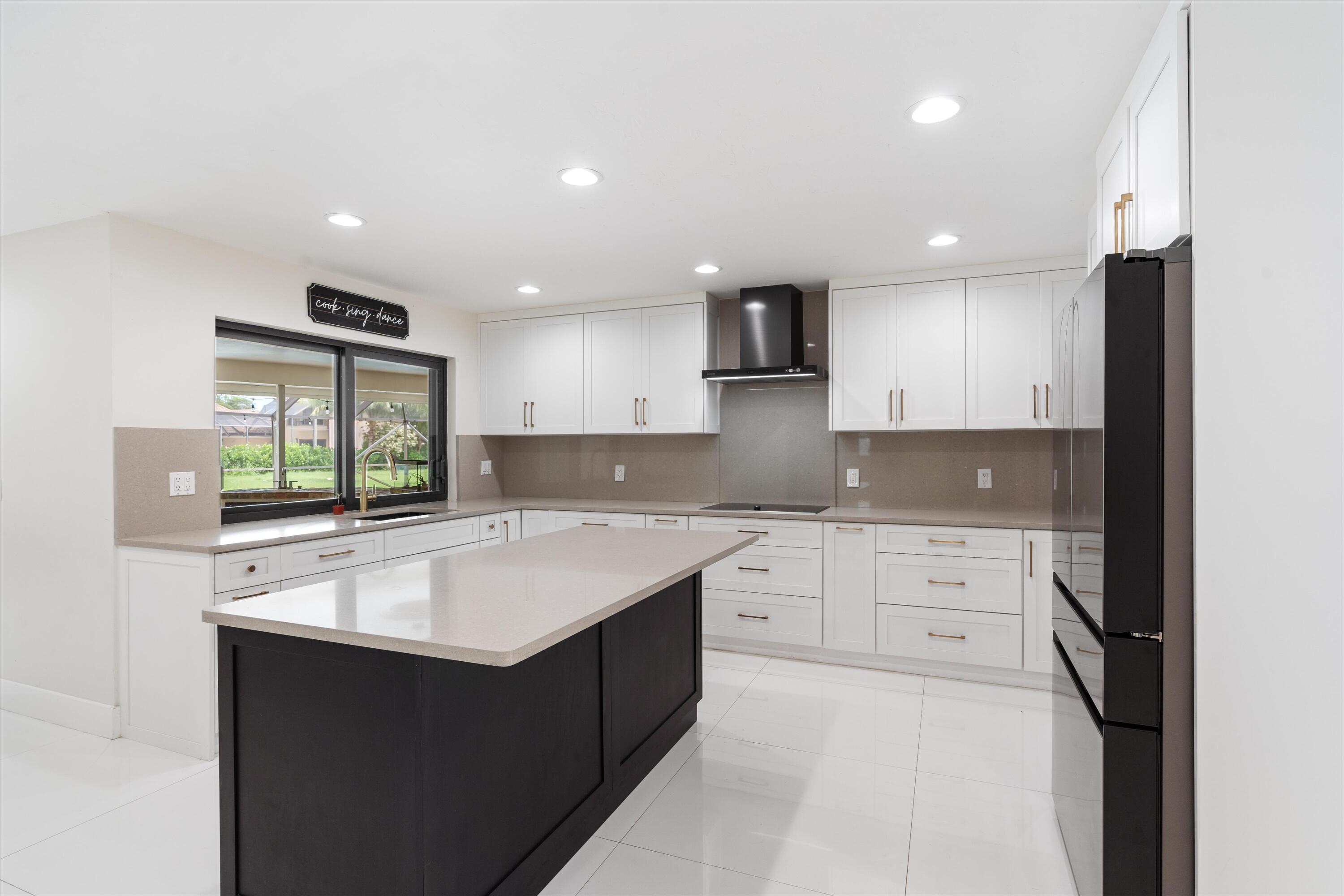 516 Muirfield Drive Atlantis, FL 33462 - Photo 11 of 43 a kitchen with a sink stove and cabinets