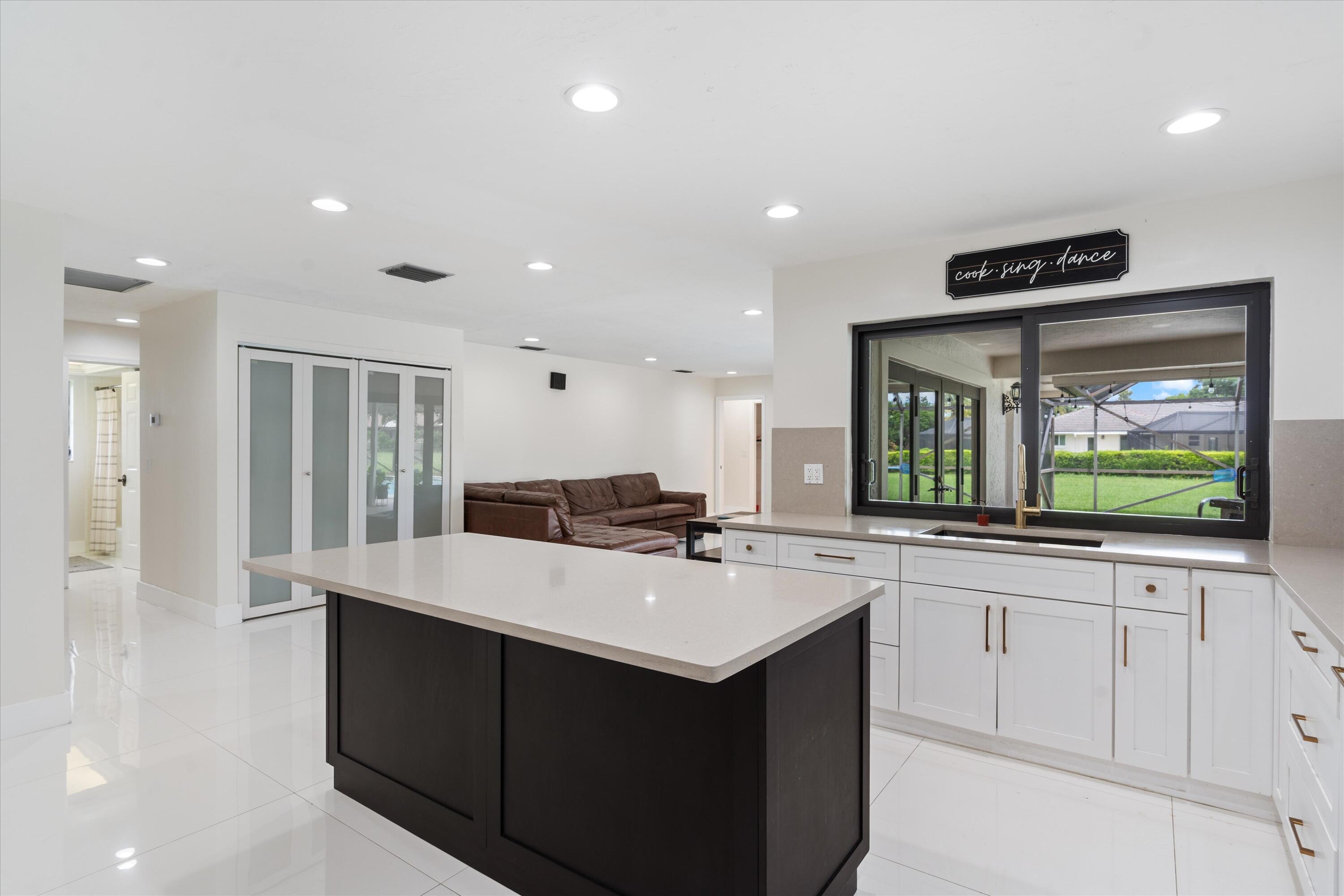 516 Muirfield Drive Atlantis, FL 33462 - Photo 12 of 43 a large kitchen with stainless steel appliances a large counter top a stove and a sink