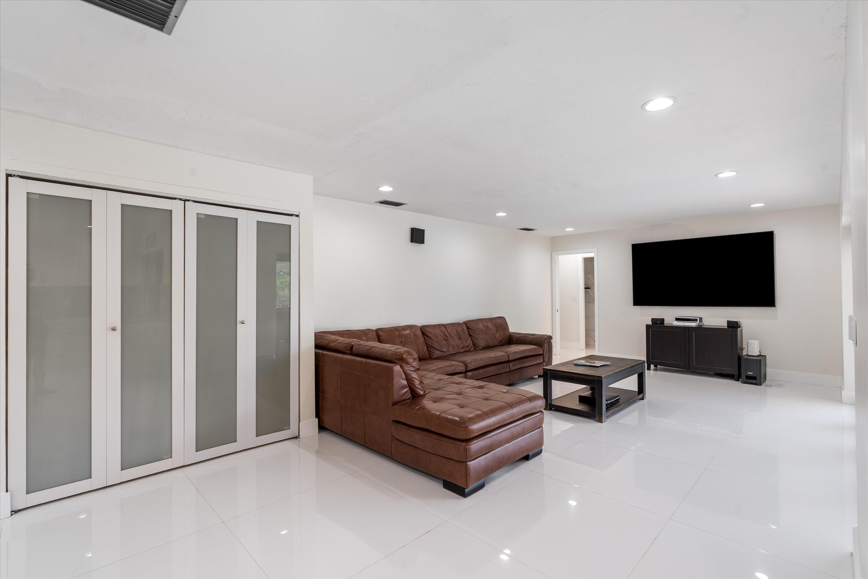 516 Muirfield Drive Atlantis, FL 33462 - Photo 13 of 43 a living room with furniture and a flat screen tv