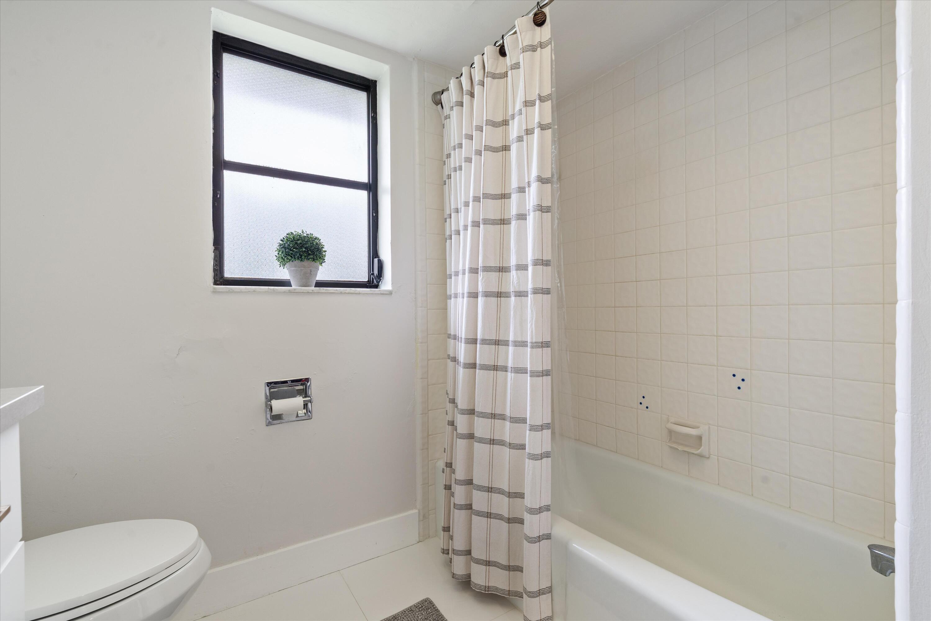 516 Muirfield Drive Atlantis, FL 33462 - Photo 21 of 43 a bathroom with a shower a toilet and a sink