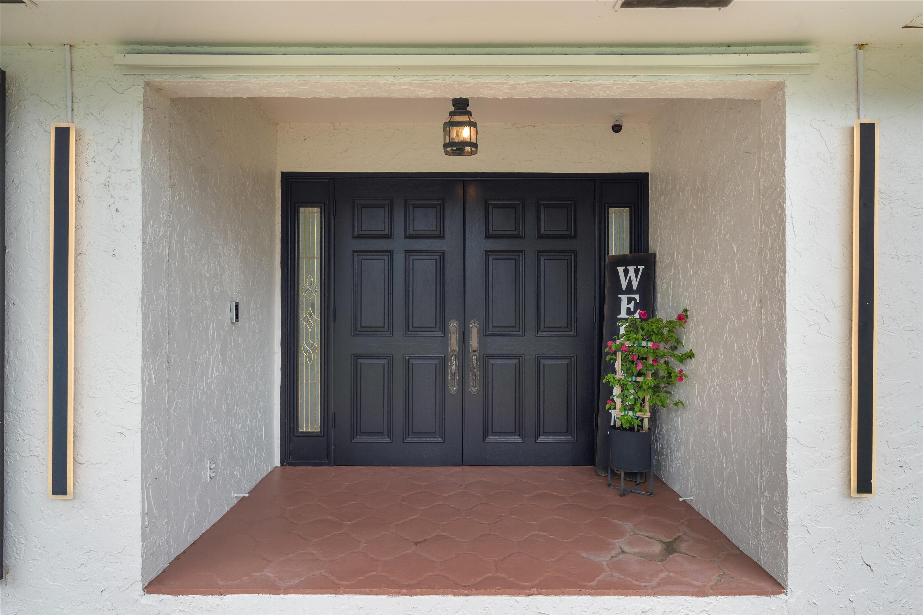 516 Muirfield Drive Atlantis, FL 33462 - Photo 4 of 43 a view of entryway with a flower pot