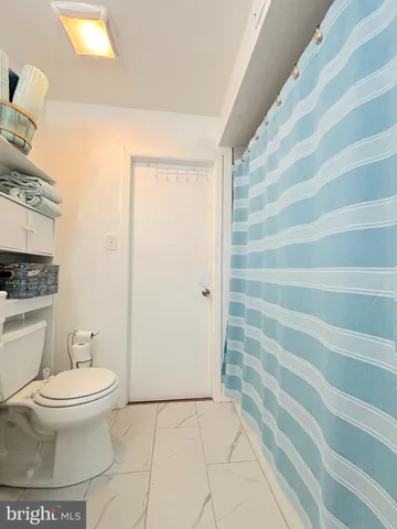 a bathroom with a toilet and a shower