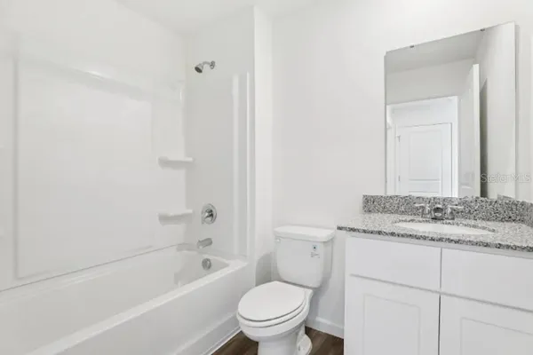 a bathroom with a granite countertop toilet a sink and a bathtub