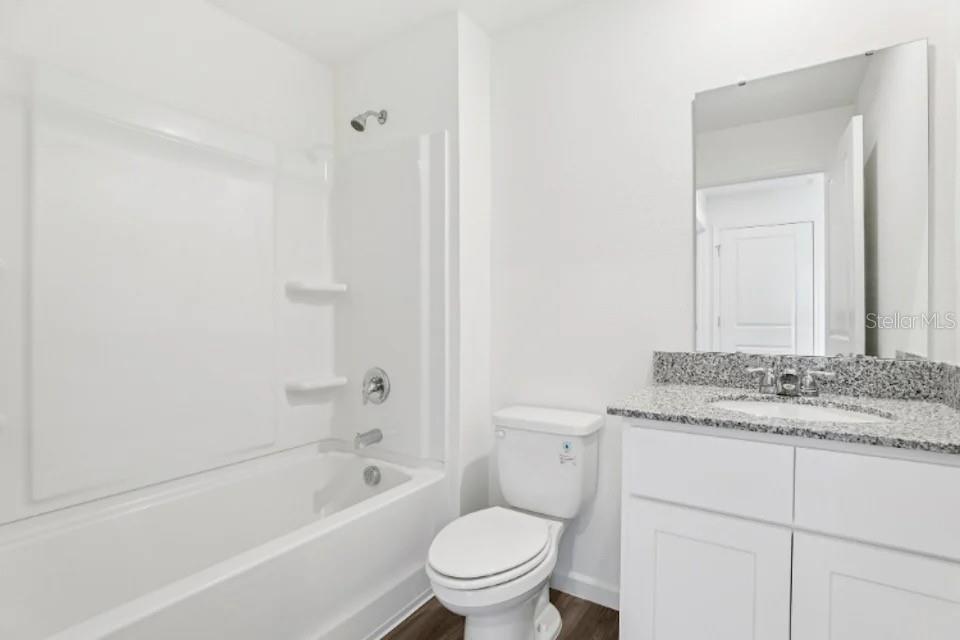 673 Hillview Loop Haines City, FL 33844 - Photo 11 of 14 a bathroom with a granite countertop toilet a sink and a bathtub