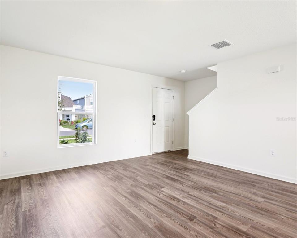 673 Hillview Loop Haines City, FL 33844 - Photo 3 of 14 an empty room with wooden floor and windows