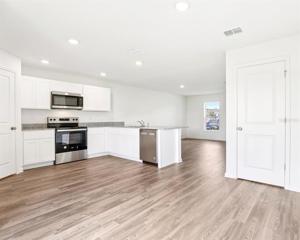673 Hillview Loop Haines City, FL 33844 - Photo 4 of 14 a view of kitchen with microwave and cabinets