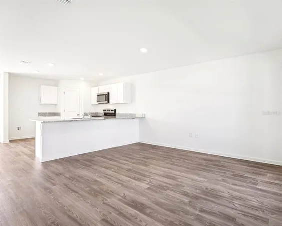 a view of kitchen with granite countertop cabinets and sink