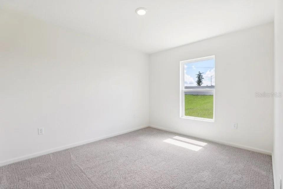 673 Hillview Loop Haines City, FL 33844 - Photo 10 of 14 a view of an empty room with a window and wooden floor