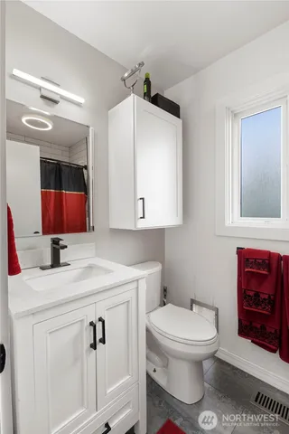a bathroom with a sink toilet vanity and mirror