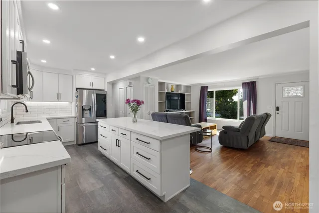a kitchen that has a lot of white cabinets and couches