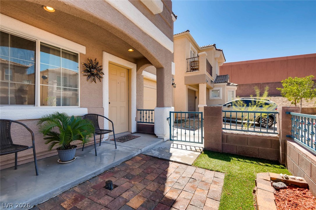 10451 Processor Court Las Vegas, NV 89129 - Photo 5 of 28 An inviting front entry welcomes guests with a tiled patio and manicured lawn.