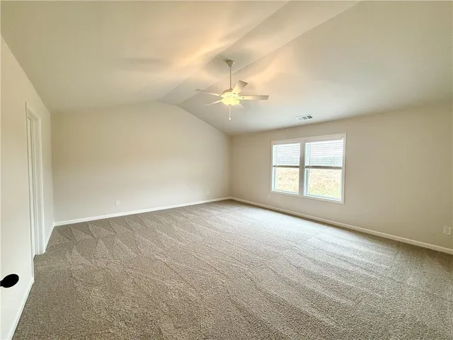 an empty room with windows and ceiling fan