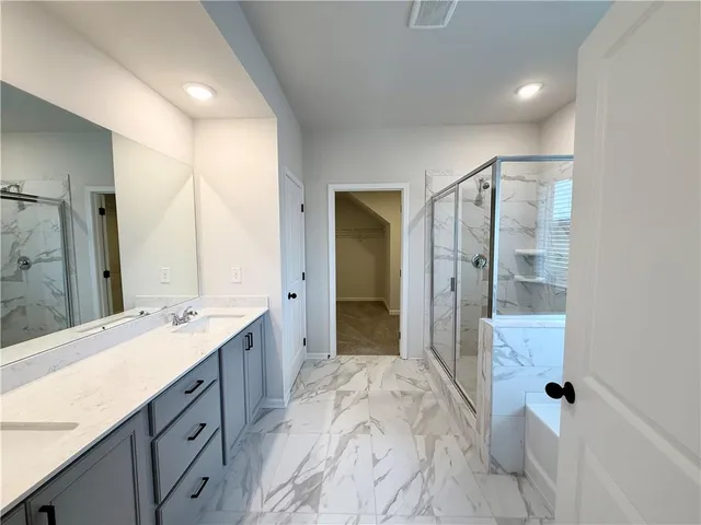 a spacious bathroom with a shower sink and mirror