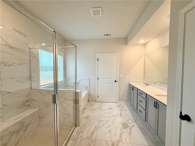 a spacious bathroom with a double vanity sink a mirror and a shower