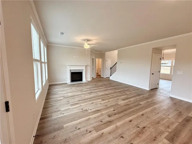 a big room with wooden floor and fireplace