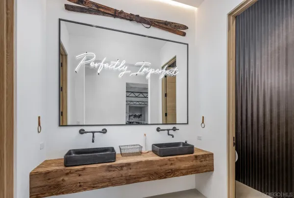 a bathroom with a double vanity sink a mirror and next to a window