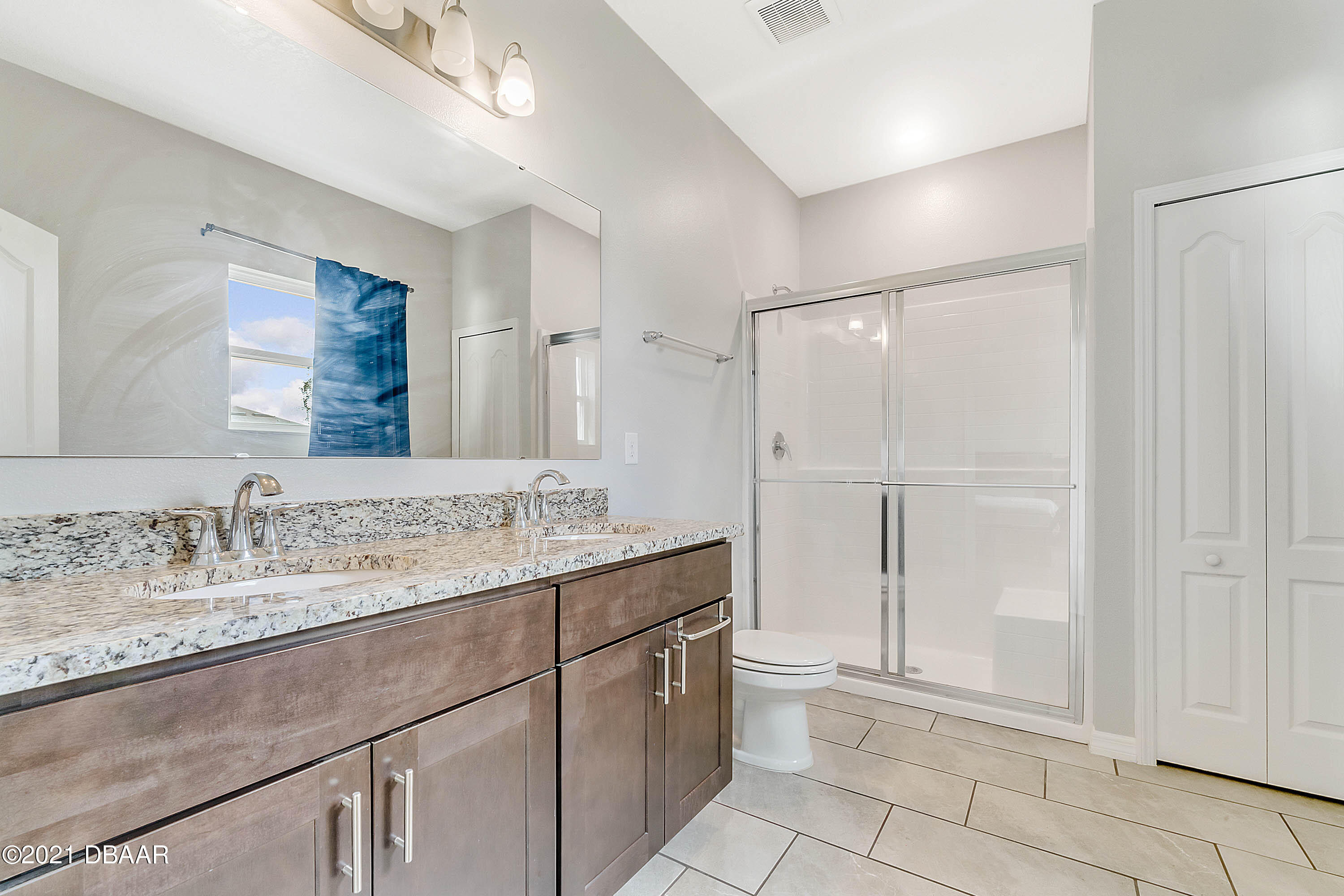 235 Jackson Loop DeLand, FL 32724 - Photo 17 of 27 a bathroom with a granite countertop sink a mirror and a shower