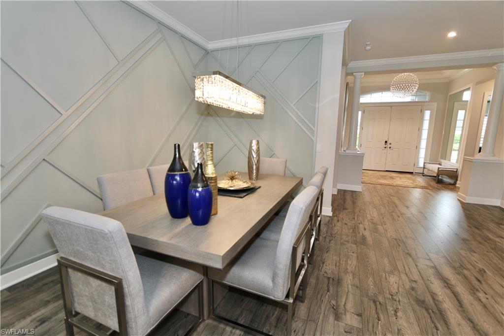 8337 Promoso Court Naples, FL 34114 - Photo 12 of 48 Dining room with a decorative wall, a chandelier, ornamental molding, and dark wood finished floors