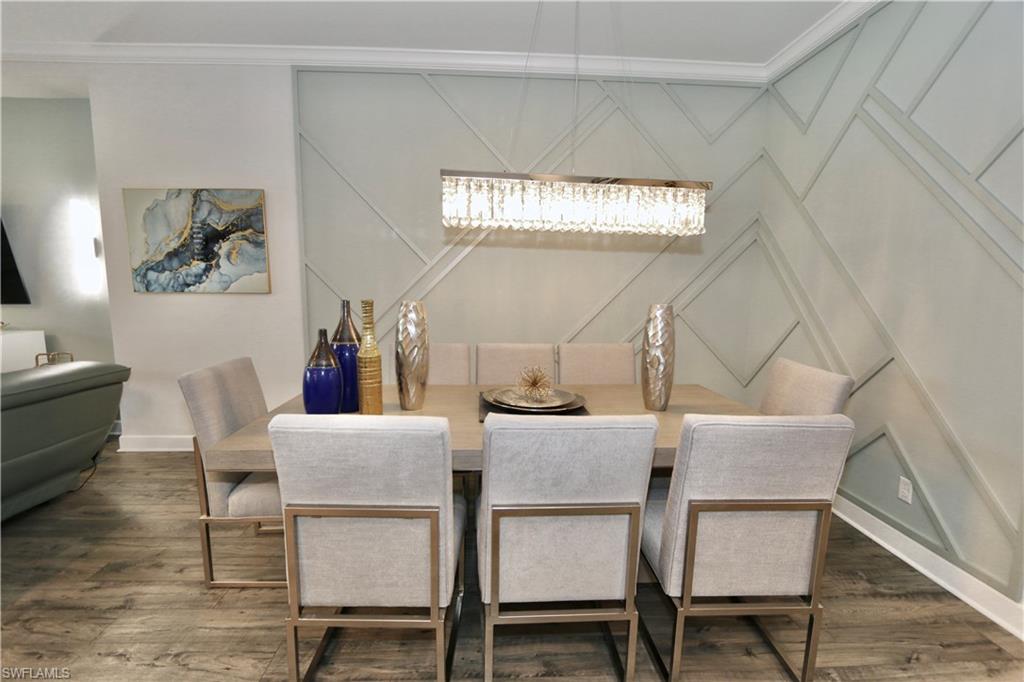 8337 Promoso Court Naples, FL 34114 - Photo 14 of 48 Dining area featuring a decorative wall, dark wood finished floors, and ornamental molding