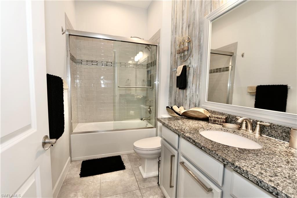 8337 Promoso Court Naples, FL 34114 - Photo 23 of 48 Full bathroom with vanity, bath / shower combo with glass door, and light tile patterned floors
