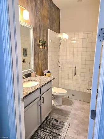 a bathroom with a granite countertop sink toilet and shower
