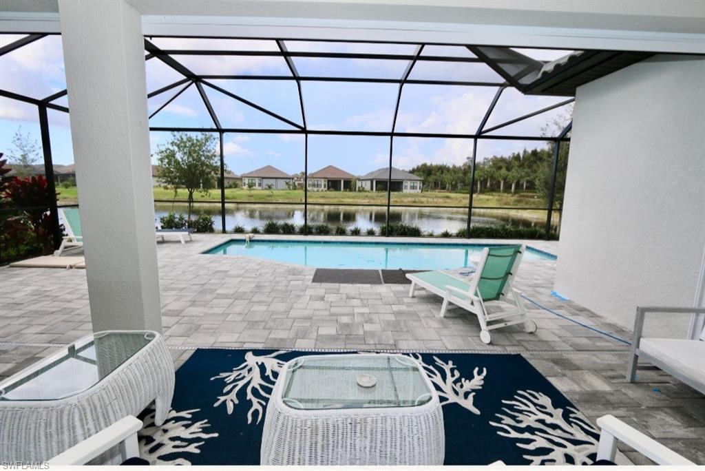 8337 Promoso Court Naples, FL 34114 - Photo 33 of 48 Outdoor pool with a sunroom, a patio area, glass enclosure, and a residential view