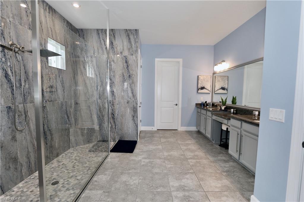 8337 Promoso Court Naples, FL 34114 - Photo 7 of 48 Full bathroom with double vanity and a marble finish shower