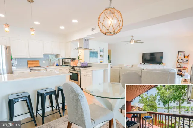 a kitchen with stainless steel appliances granite countertop a stove a refrigerator a microwave oven a dining table and chairs with wooden floor