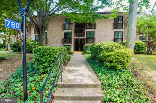 a front view of a house with a yard and potted plants