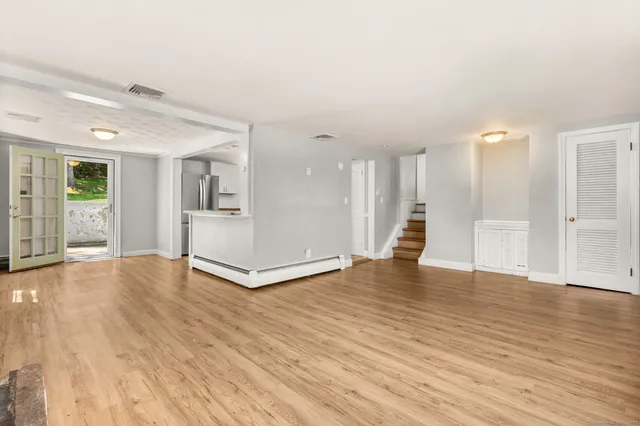 an empty room with wooden floor and a fireplace