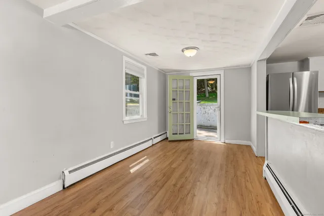 a view of empty room with wooden floor and fireplace