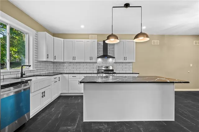 a kitchen with granite countertop a sink cabinets and window