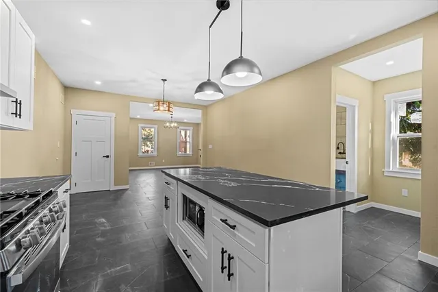 a kitchen with granite countertop sink stove and cabinets