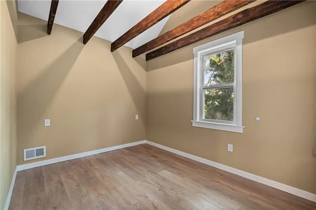 a view of hallway with window and wooden floor