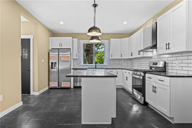 a kitchen with kitchen island granite countertop a sink stainless steel appliances and cabinets