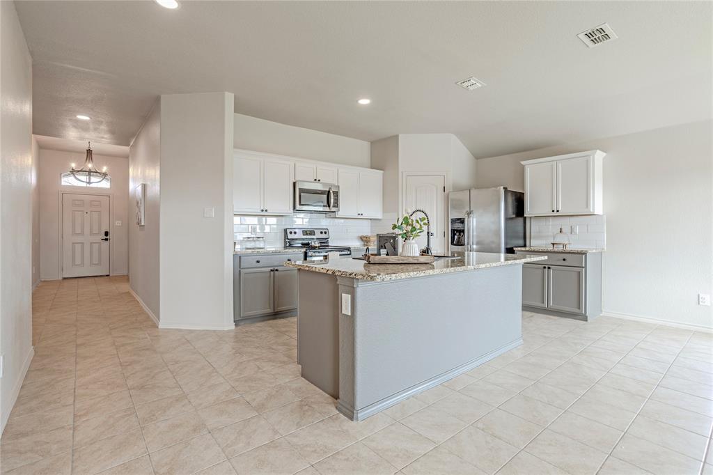 a large kitchen with cabinets and stainless steel appliances