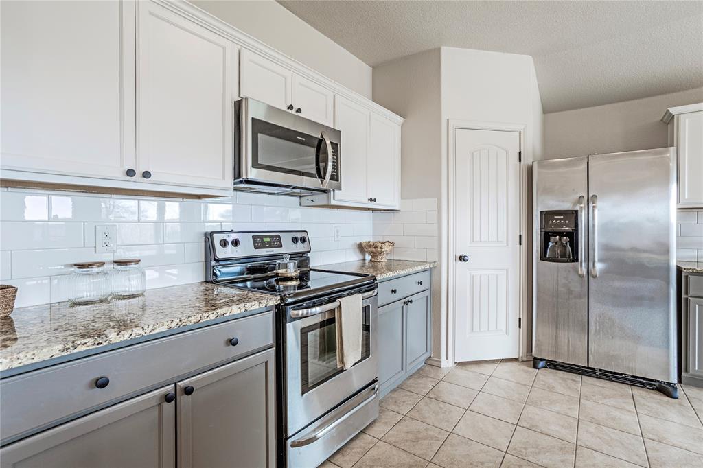345 Chestnut Lane Ponder, TX 76259 - Photo 18 of 29 a kitchen with stainless steel appliances granite countertop white cabinets a sink a stove a refrigerator and white cabinets