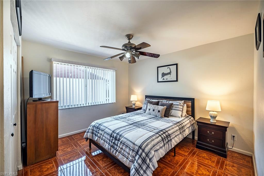 3420 Frosty Way, Unit 4902 Naples, FL 34112 - Photo 11 of 31 a bedroom with a bed and a chandelier